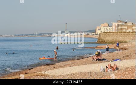 Brighton UK 14th September 2020 - Sunbathers enjoy the hot sunny weather on Brighton beach as temperatures are forecast to reach 30 degrees in parts of the South East  : Credit Simon Dack / Alamy Live News Stock Photo