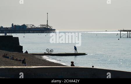 Brighton UK 14th September 2020 - A fisherman enjoys the hot sunny weather on Brighton beach as temperatures are forecast to reach 30 degrees in parts of the South East  : Credit Simon Dack / Alamy Live News Stock Photo