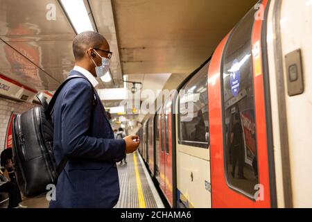 London- September 2020: Businessman wearing a face mask on the London Underground Stock Photo