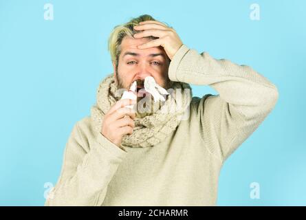 Sick leave. Cold flu remedies. Runny nose recovery. Runny nose and symptoms of cold. Fast recovery. Man scarf hold nasal spray. Medicines effective recovery. Allergy medical treatment. Health problem. Stock Photo