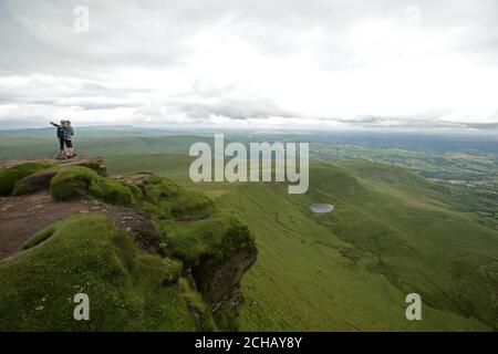 Hikers take a selfie with the view of Brecon Beacons National Park from the summit of Corn Du mountain, in Wales. PRESS ASSOCIATION Photo. Picture date: Tuesday July 12, 2016. Photo credit should read: Yui Mok/PA Wire Stock Photo