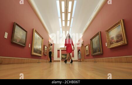 A woman walks through part of the Clore Gallery which is displaying various works by JMW Turner which have returned to Tate Britain in London following a major international tour. Stock Photo