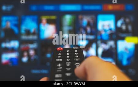 Male hand with remote control pointing on Smart TV. Stock Photo