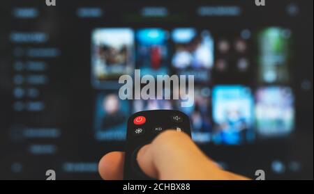 Male hand with remote control pointing on Smart TV. Stock Photo