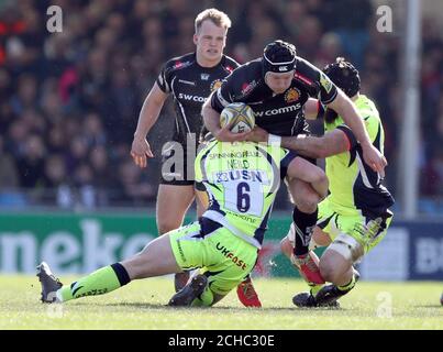 Exeter Chiefs' Thomas Waldrom (centre) is tackled by Sale Sharks' Cameron Neild (left) and Bryn Evans during the Aviva Premiership match at Sandy Park, Exeter.