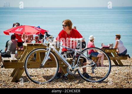 A cyclist takes a much deserved rest on Brighton Beach after taking part in the British Heart Foundation's 42nd London to Brighton Bike Ride, supported by Tesco and Jaffa. Stock Photo
