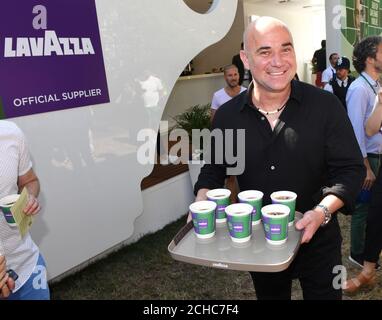 EDITORIAL USE ONLY Former Wimbledon champion and Lavazza Global Ambassador Andre Agassi hands out coffee to tennis fans at The All England Lawn tennis and Croquet Club in Wimbledon to celebrate Lavazzas 7th year as the Official Coffee of The Championships. Stock Photo