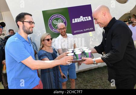 EDITORIAL USE ONLY Former Wimbledon champion and Lavazza Global Ambassador Andre Agassi hands out coffee to tennis fans at The All England Lawn Tennis and Croquet Club in Wimbledon to celebrate Lavazza&Otilde;s 7th year as the Official Coffee of The Championships. Stock Photo