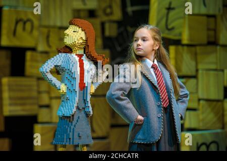 Actress Emma Moore, who plays Matilda in the Royal Shakespeare Company's Matilda The Musical stage show at the Cambridge Theatre stands with a unique LEGO brick build of the character 'Matilda', to celebrate Roald Dahl Day, which marks the storyteller's birthday on September 13th, London. Stock Photo