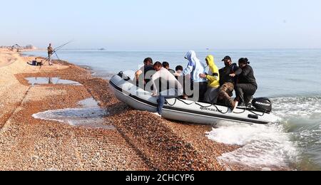 A group of people thought to be migrants arrive in an inflatable boat at Kingsdown beach, near Dover, Kent, after crossing the English Channel. Stock Photo