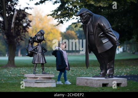 Amilie Bravington, six, from High Wycome takes a look at a statue of Roald Dahl's Matilda which was unveiled in Great Missenden in Buckinghamshire, alongside one of President Donald Trump, to celebrate the 30th Anniversary of Matilda the novel. Stock Photo