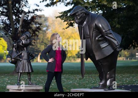 Mollie Sutton, eight, from Romford takes a look at a statue of Roald Dahl's Matilda which was unveiled in Great Missenden in Buckinghamshire, alongside one of President Donald Trump, to celebrate the 30th Anniversary of Matilda the novel. Stock Photo