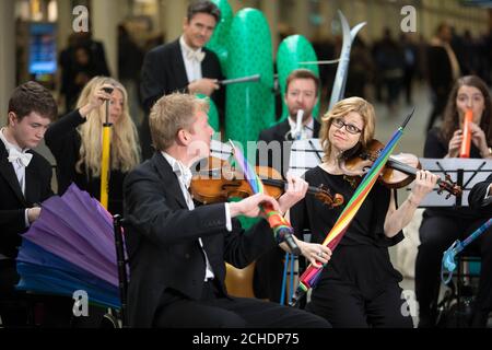 Members of the Royal Philharmonic Concert Orchestra perform with instruments and other unusual items that have been left on trains to launch East Midlands Trains Found It! service, a free web-based platform allowing customers to track and claim lost items, London St Pancras. Stock Photo