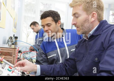 portrait of two mechanics repairing modern laser cutting machine Stock Photo
