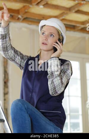 woman on building site using smartphone Stock Photo