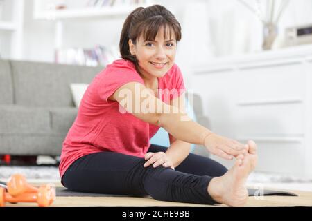 woman in sportswear doing simple morning exercises at home Stock Photo