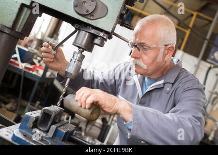 senior operator works at machine Stock Photo