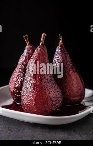 Poached pears in red wine on black background Stock Photo