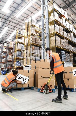 EMBARGOED TO 0001 WEDNESDAY AUGUST 7 EDITORIAL USE ONLY Staff at the Amazon Fulfilment Centre in Peterborough prepare to package and send fax machines to customers as Amazon announce a flash sale of up to 50% on them to celebrate the Premier League transfer deadline day and their first season broadcasting live matches. Stock Photo