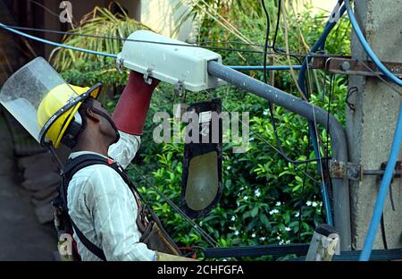 Electricians repairing a street lighting on pole Stock Photo