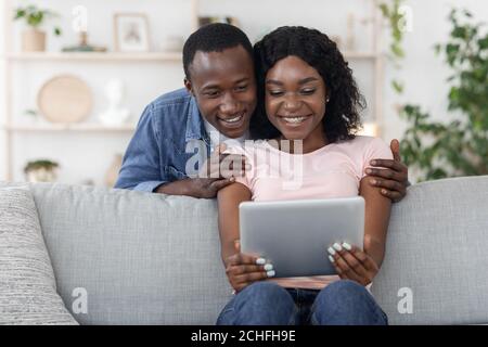 Happy lovers using digital tablet, checking new application Stock Photo