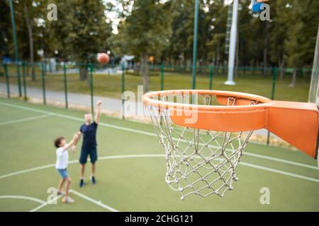 Man throwing ball, playing basketball with his son Stock Photo