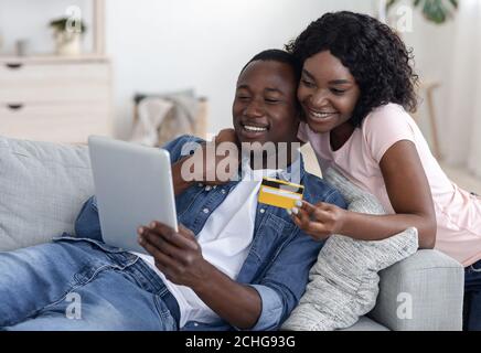 Happy married couple with digital tablet buying furniture online Stock Photo