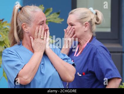Staff react outside Salford Royal Hospital in Manchester during a minute's silence to pay tribute to the NHS staff and key workers who have died during the coronavirus outbreak. Stock Photo