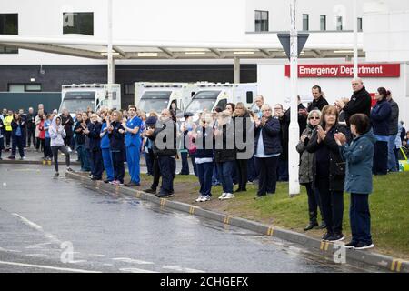 NHS staff, emergency services workers and members of the public watch as the funeral cortege of NHS worker Jane Murphy passes the Accident and Emergency department at the Edinburgh Royal Infirmary, Edinburgh. Stock Photo