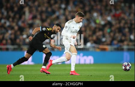 Real Madrid's Federico Valverde turns away from Manchester City's Riyad Mahrez during the UEFA Champions League round of 16 first leg match at the Santiago Bernabeu, Madrid. Stock Photo