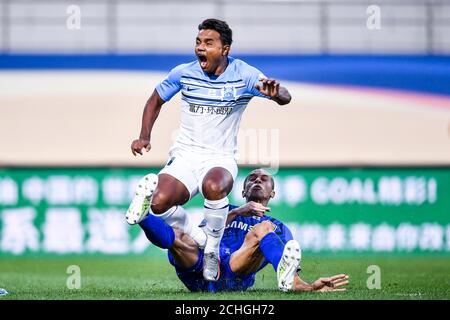 Brazilian football player Renato Ribeiro Calixto or Renatinho of Guangzhou R&F F.C., left, falls down during the eleventh -round match of 2020 Chinese Super League (CSL) against Jiangsu Suning F.C., Dalian city, northeast China's Liaoning province, 13 September 2020. Jiangsu Suning F.C. and Guangzhou R&F F.C. drew the game with 3-3. Stock Photo