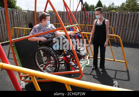 Embargoed to 0001 Monday June 22 Gregor Marshall with his mum Karen as Gregor has a ride on the wheelchair swing in the outside therapy area at the Craighalbert Centre. Coronavirus adaptations have been installed at the Scottish Centre for Children with Motor Impairments, Craighalbert Centre, Cumbernauld, as Scotland continues gradually lifting coronavirus lockdown measures. Stock Photo