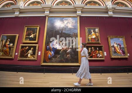 EMBARGOED TO 1700 SATURDAY JULY 4 A visitor wearing PPE walks past The Adoration of the Shepherds, 1640, by Guido Reni at the National Portrait Gallery, London, as it prepares to reopen following the easing of coronavirus lockdown restrictions across England. Stock Photo