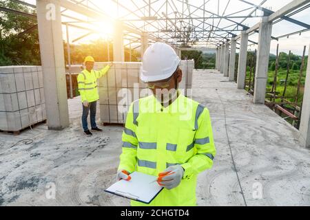 Supervisor Engineering with the worker in uniform safety at the construction site Stock Photo