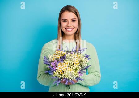 Close-up portrait of her she nice-looking attractive lovely cute winsome cheerful cheery girl holding in hands wild flowers isolated on gray bright Stock Photo