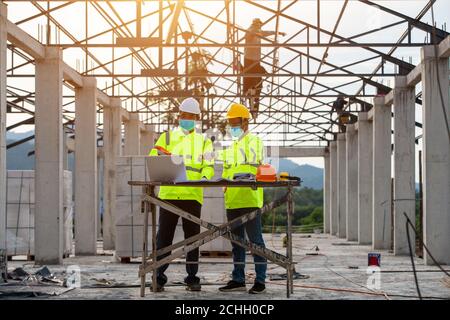 Engineering and supervisor working together in the construction site and masked Stock Photo