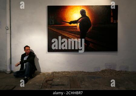 Street artist James Cochran, also known as Jimmy C, poses next to his spray painted picture 'Defy' at the Pure Evil Gallery in London October 10, 2013. The paintings were originally inspired by the London riots in 2011. REUTERS/Stefan Wermuth (BRITAIN - Tags: ENTERTAINMENT SOCIETY)