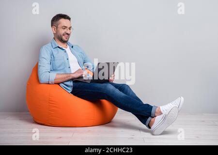 Portrait of his he nice attractive focused cheerful cheery content gray-haired guy using laptop working remotely executive management isolated over Stock Photo