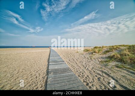 Romantic wooden trail or boardwalk on a beach leads to a calm Baltic Sea conveying realisation and relax concepts. Path to success illustration Stock Photo