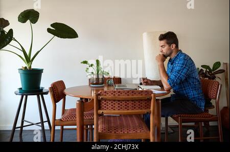 Young man working online with a laptop from home Stock Photo