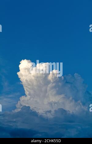 Dark cumulus cloud formation against a very dark blue background Stock Photo