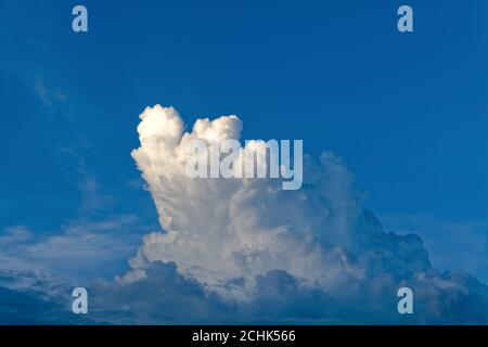 Dark cumulus cloud formation against a very dark blue background Stock Photo