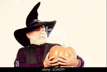 Magic concept. Experienced and wise. Halloween tradition. Cosplay outfit. Wizard costume hat Halloween party. Magician witcher old man. Senior man white beard celebrate Halloween with pumpkin. Stock Photo