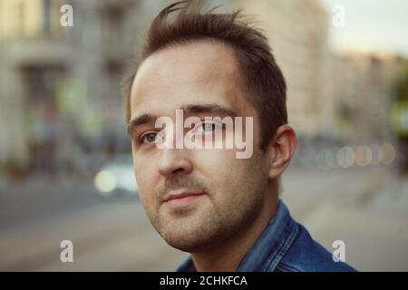 Portrait of a young pensive caucasian attractive man 27 years old who is walking in the city. Stock Photo