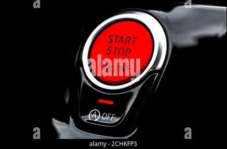 Car dashboard with focus on red engine start stop button. Modern car interior details. start/stop button. Car inside. Ignition remote starter Stock Photo