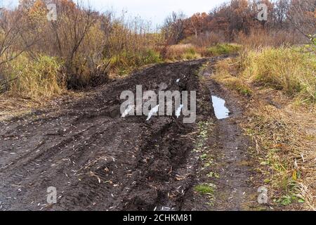 Deep ruts in the slushy autumn road Stock Photo