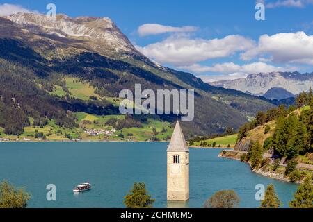 Top view of a cruise on Lake Resia near the old submerged bell tower of Curon Venosta, South Tyrol, Italy Stock Photo