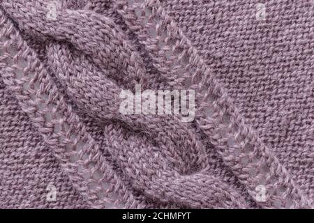 Openwork pattern knitted with needles from pink wool yarn. Stock Photo