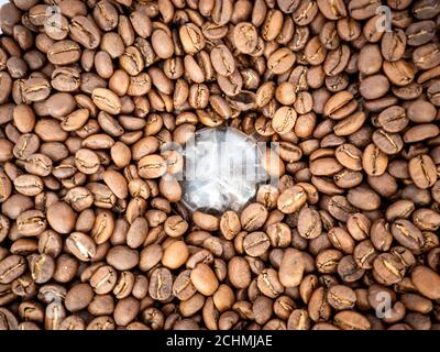 Coffee beans texture. Full frame background texture of coffee beans, top down, in a commercial grinder. Stock Photo