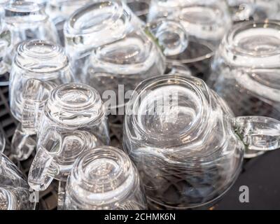 Glass Coffee Cups. Full frame stacked glass coffee cups on the heating element of a commercial espresso coffee machine. Stock Photo